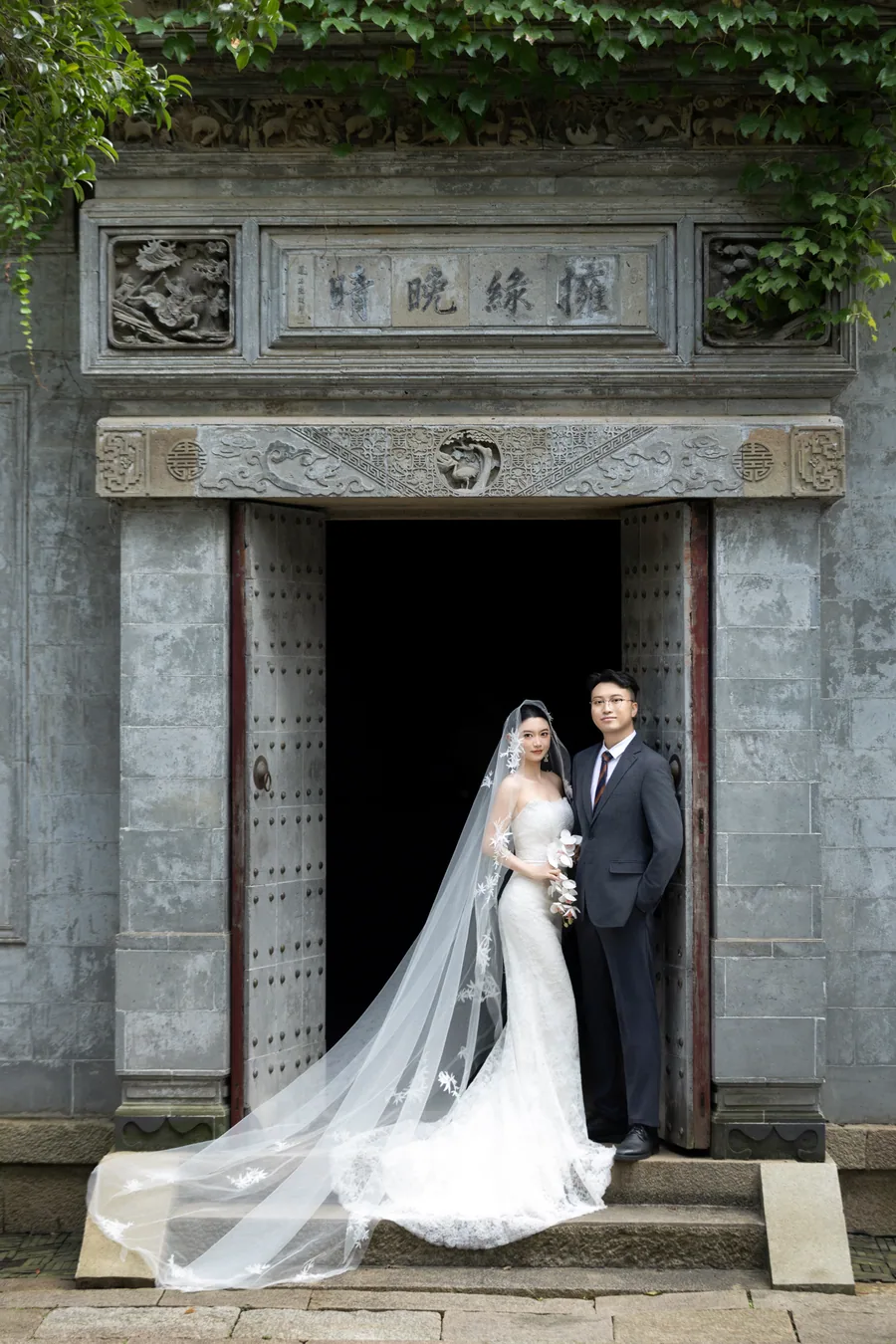 新人站在古建门前的婚纱合影